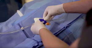 Gloved hands insterting a catheter